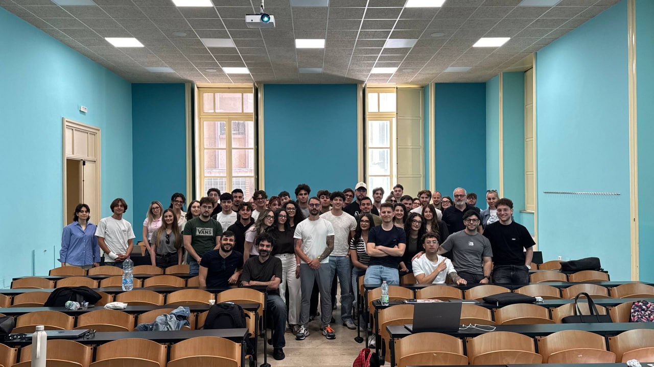 Foto di gruppo con studenti e membri di AI Family in un’aula universitaria